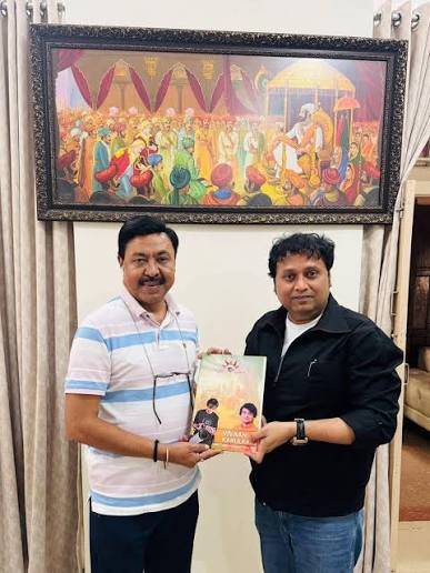 Ashutosh Dumbare with a visitor, holding a book, at an informal meeting.