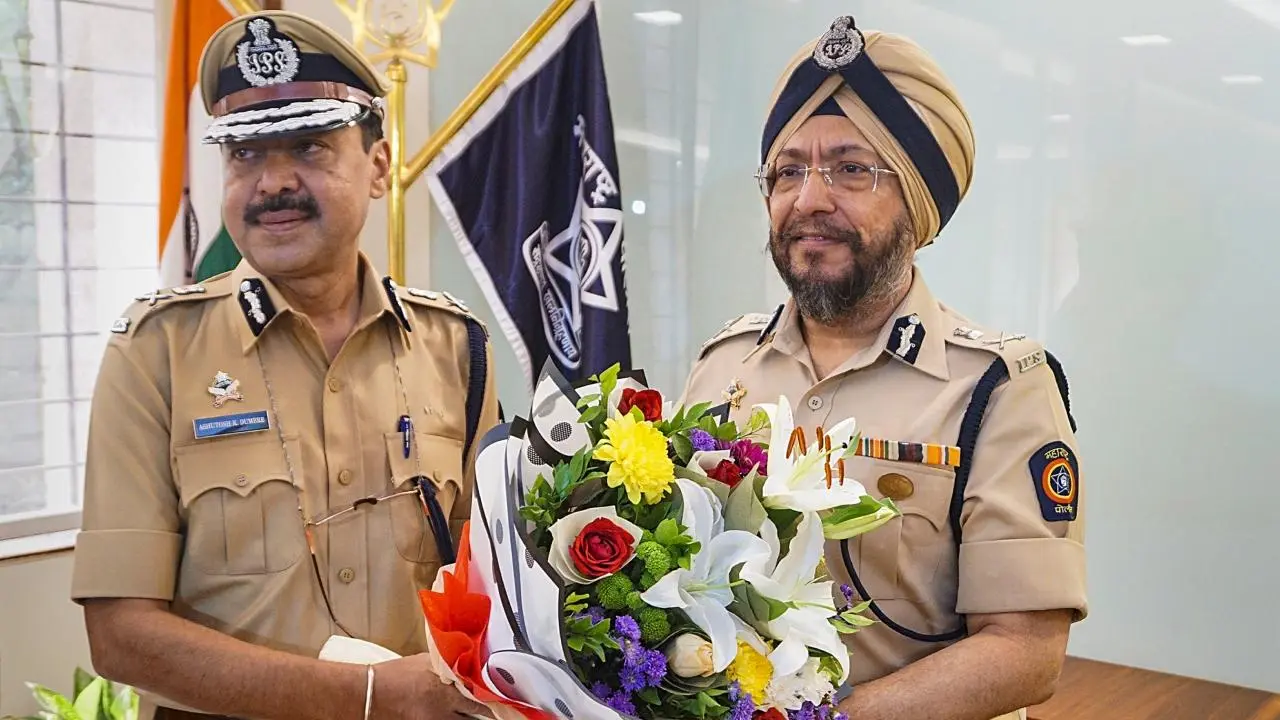 Ashutosh Dumbare in uniform at the Thane police commissionerate, receiving a bouquet from a senior Maharashtra Police officer.