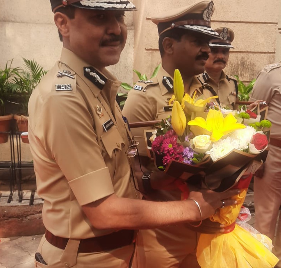 Ashutosh Dumbare in uniform holding a bouquet, with fellow Maharashtra Police officers at a departmental function.