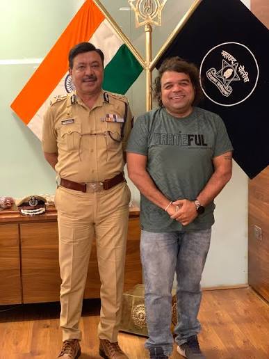 Ashutosh Dumbare in Maharashtra Police uniform standing with a visitor at his office in Thane.
